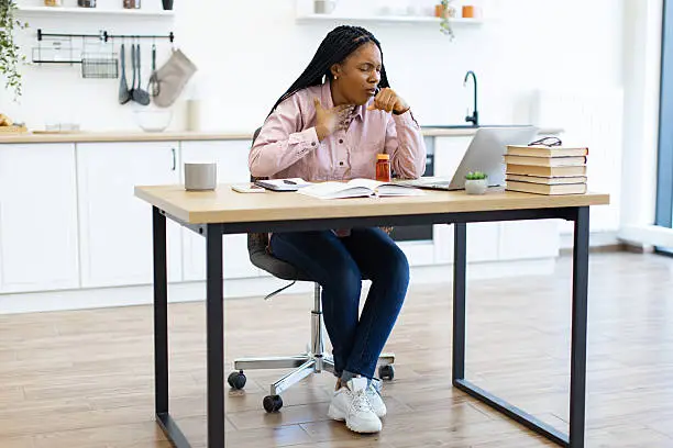 A woman business owner at her desk, hand to her chin, weighing a decision
